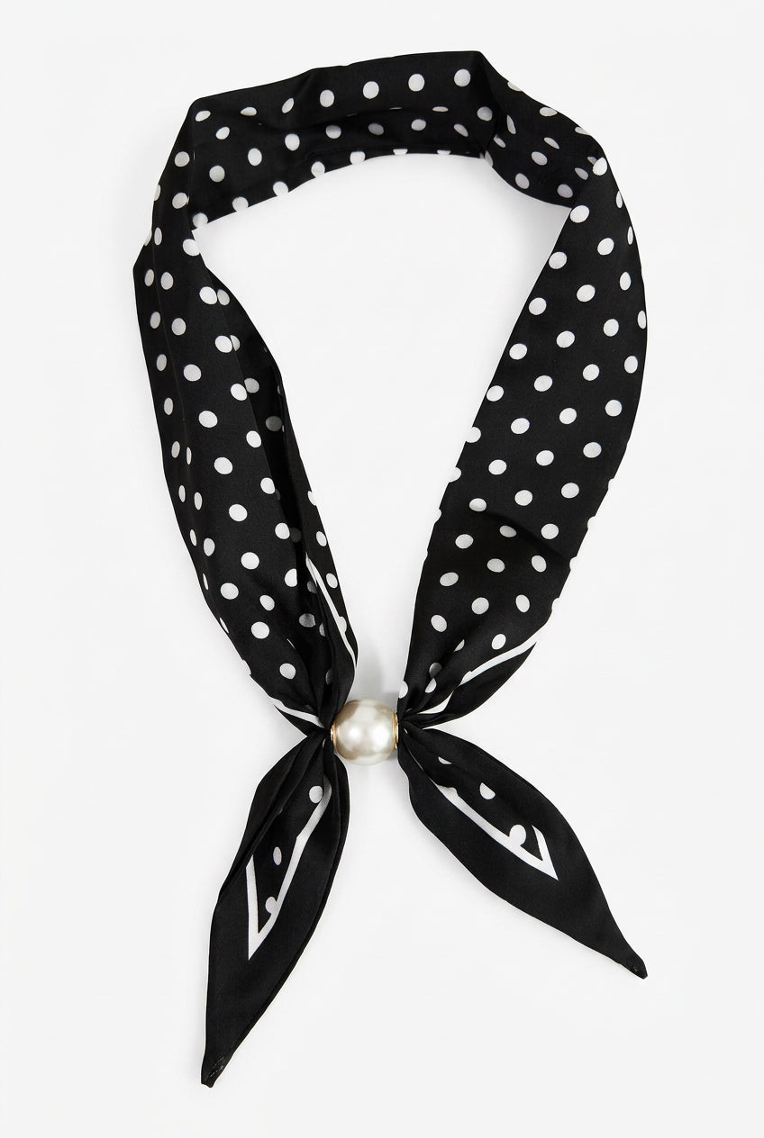 Black and white polka dot magnetic scarf necklace with white border trim, pointed ends and pearl-look front accent, front view.
