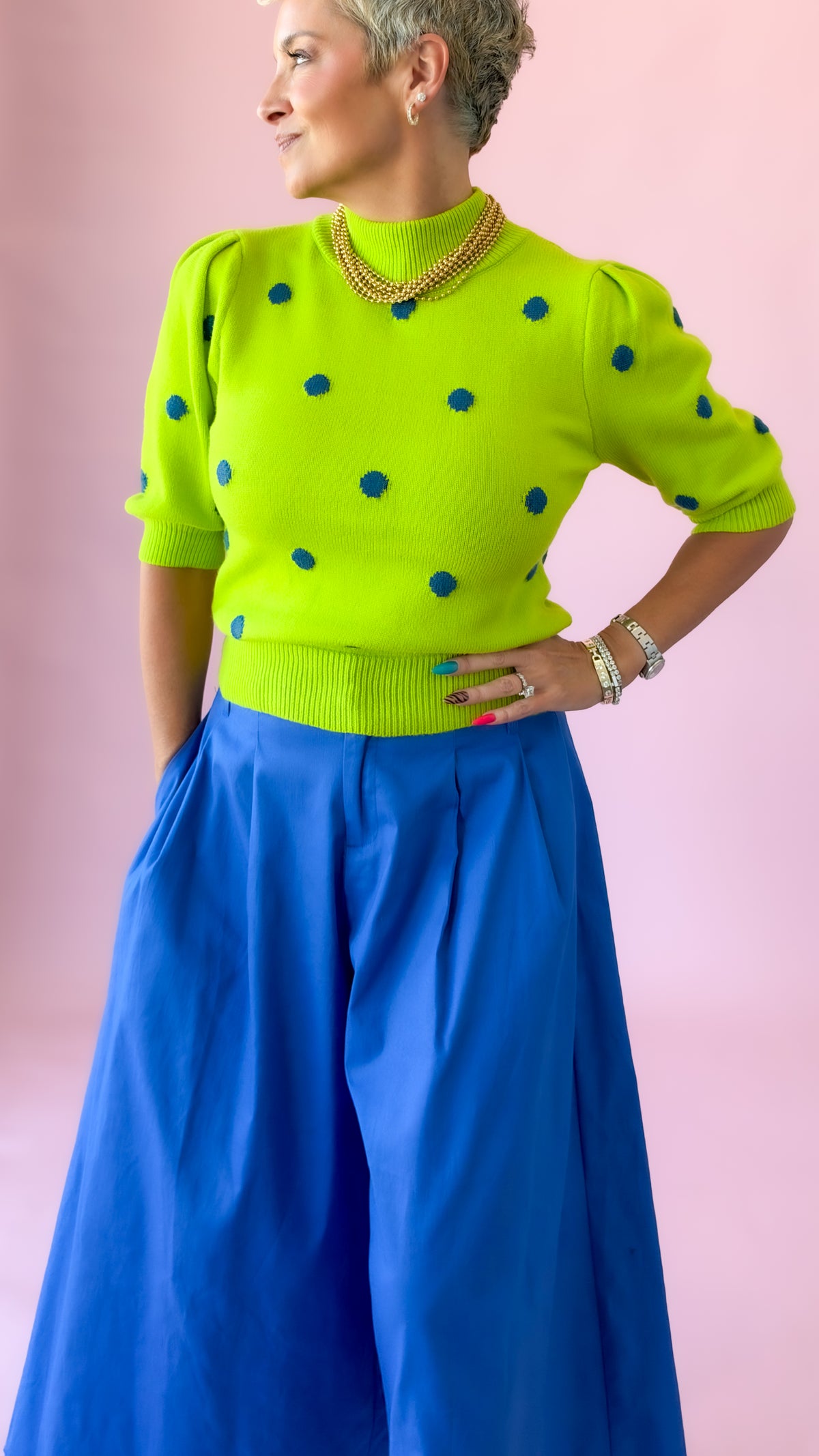 Lime dot mock neck sweater with hand on hip, side angle
