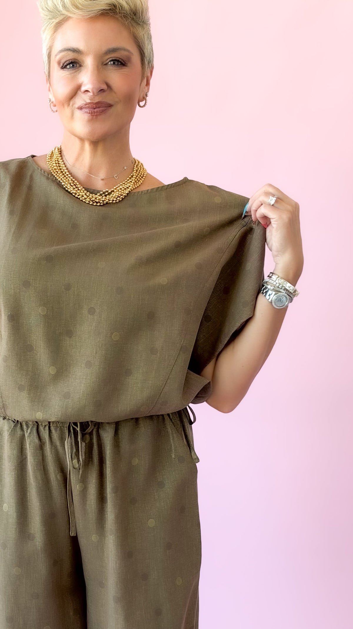 Close-up of brown round neck polka dot top with dolman sleeves