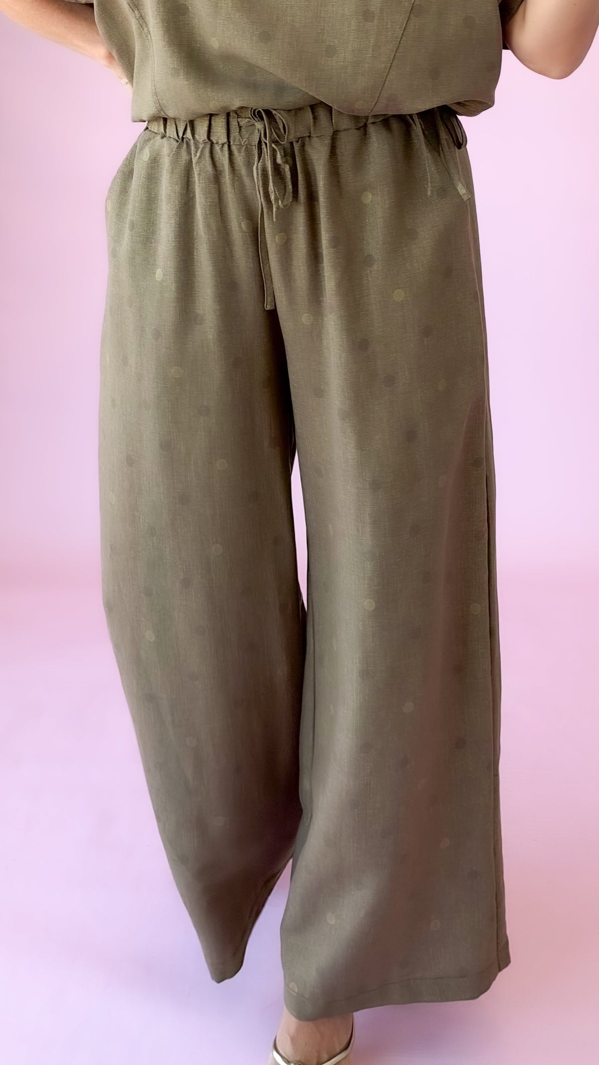 Close-up of brown wide-leg polka dot pants with drawstring waist