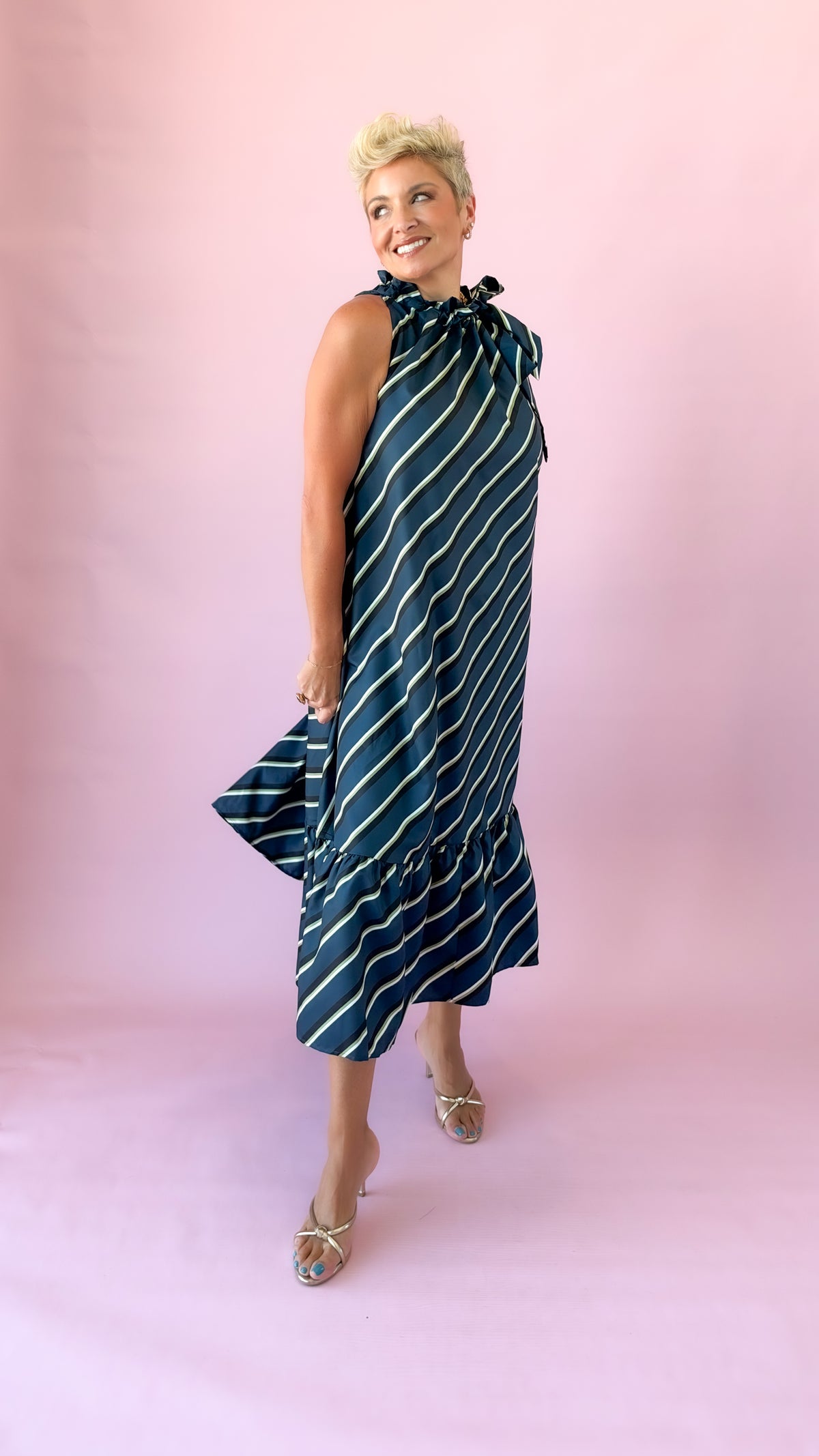 Side view of teal striped sleeveless midi dress with flounce hem