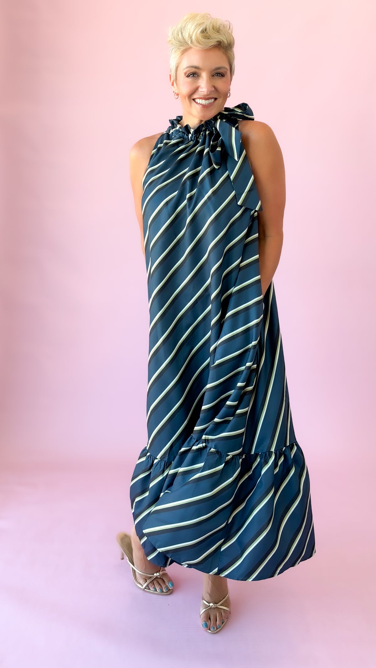 Teal and white diagonal striped sleeveless midi dress with tie neck and ruffle hem