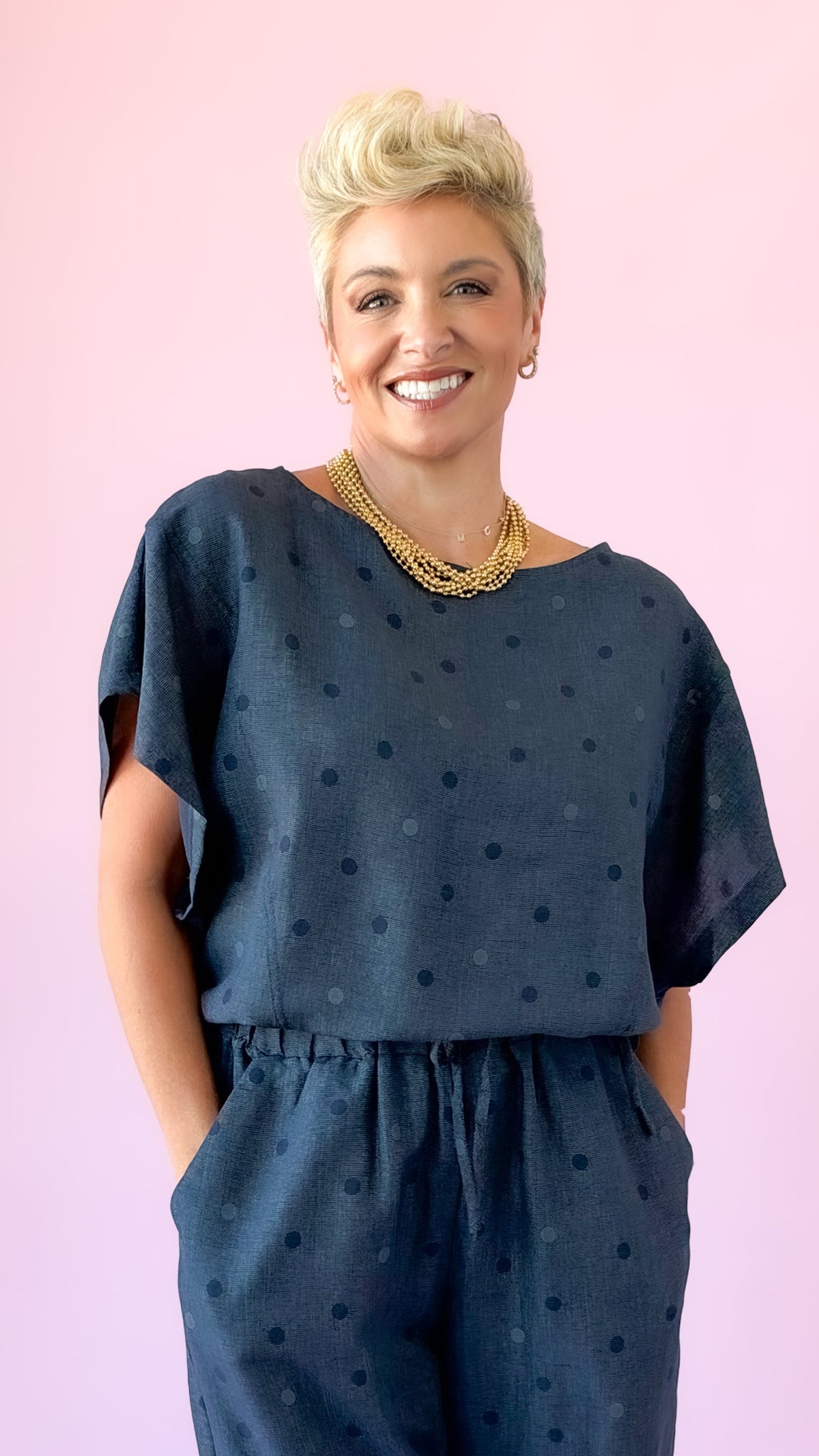 Close-up of indigo round neck polka dot top with short dolman sleeves