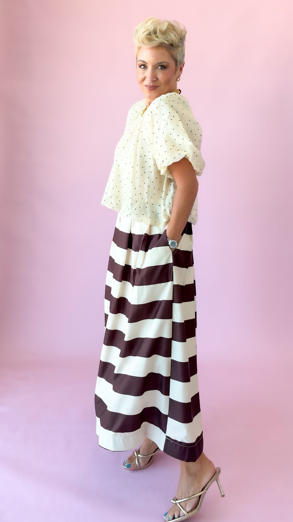 Side view of ivory flutter puff sleeve top with brown striped midi skirt