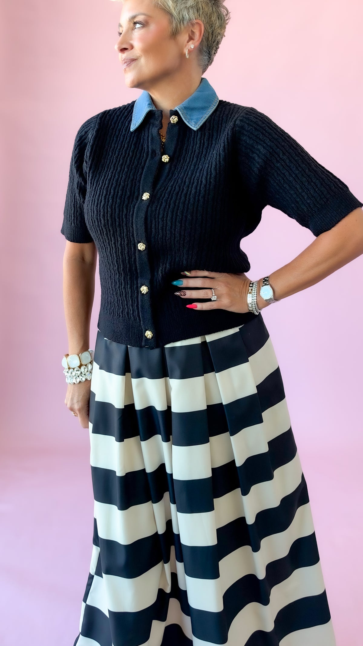 Black cable knit button-up sweater with denim collar, hand on hip