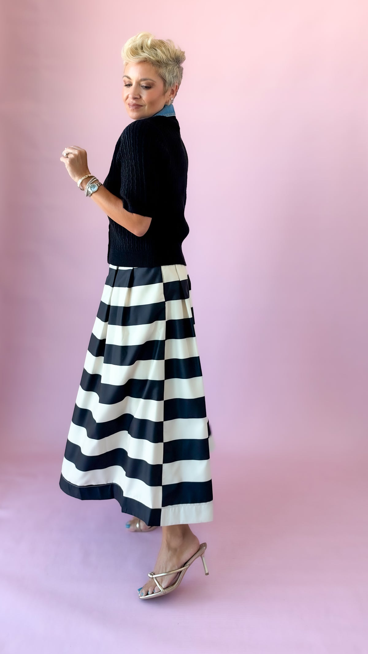 Side profile of the full black and white striped pleated midi skirt