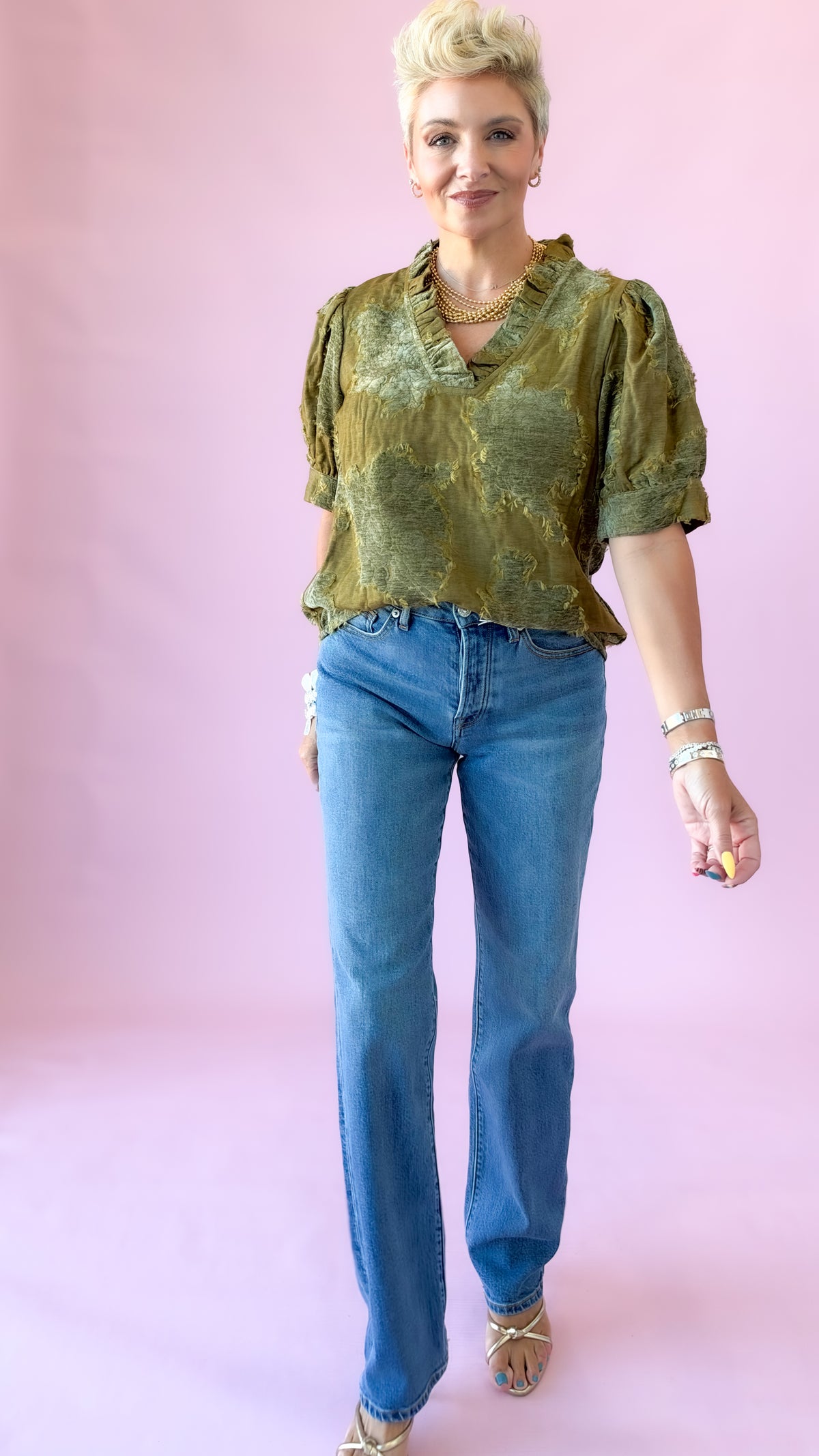 Model walking in medium wash Westgate vintage straight jeans and green printed top