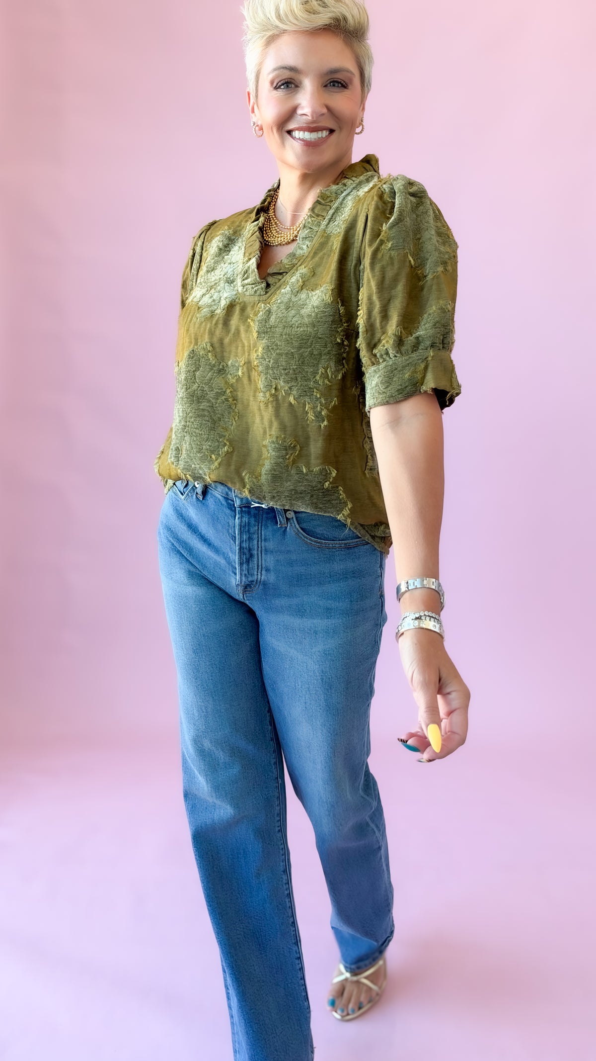 Olive luxe patchwork top with ruffle neckline worn with medium wash jeans