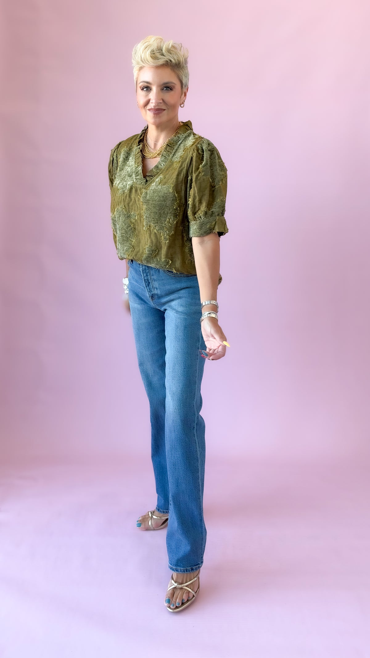 Full-length view of olive luxe patchwork top styled with straight-leg jeans