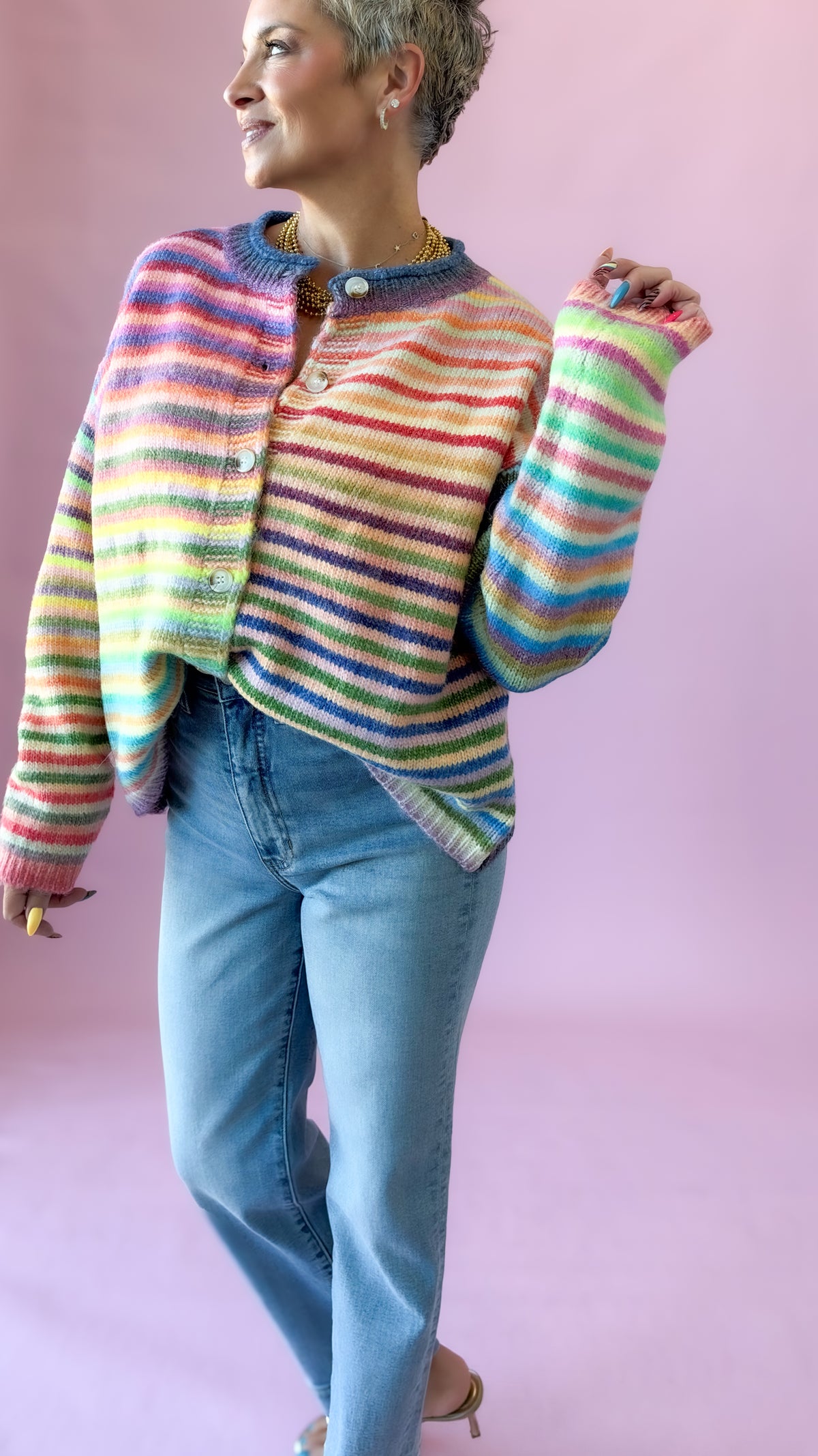 Close-up of multicolor striped button-up cardigan worn with light jeans