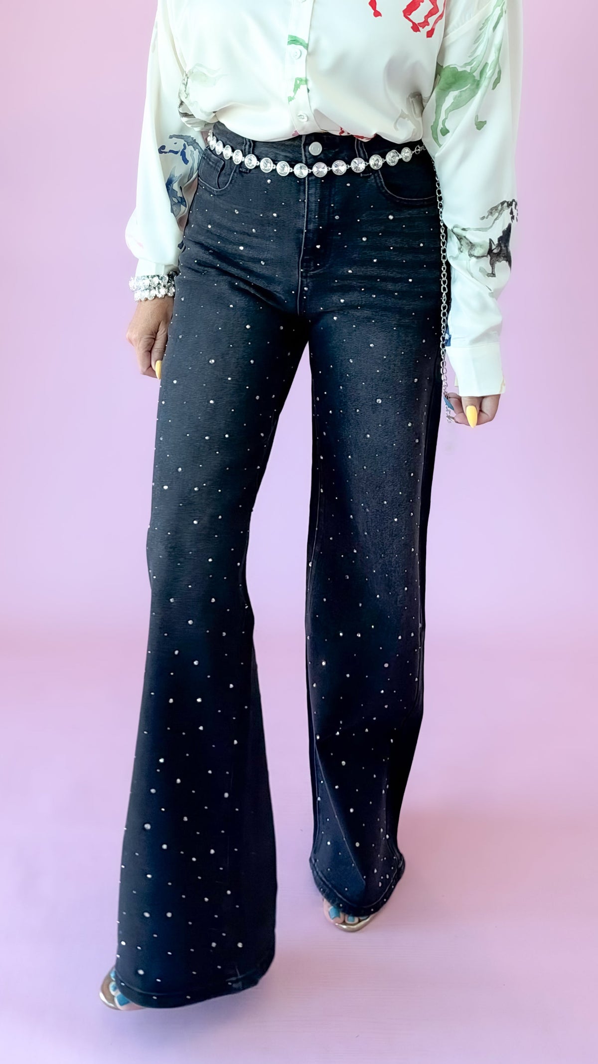 Black wash flare jeans with allover rhinestone studs, styled with a white blouse