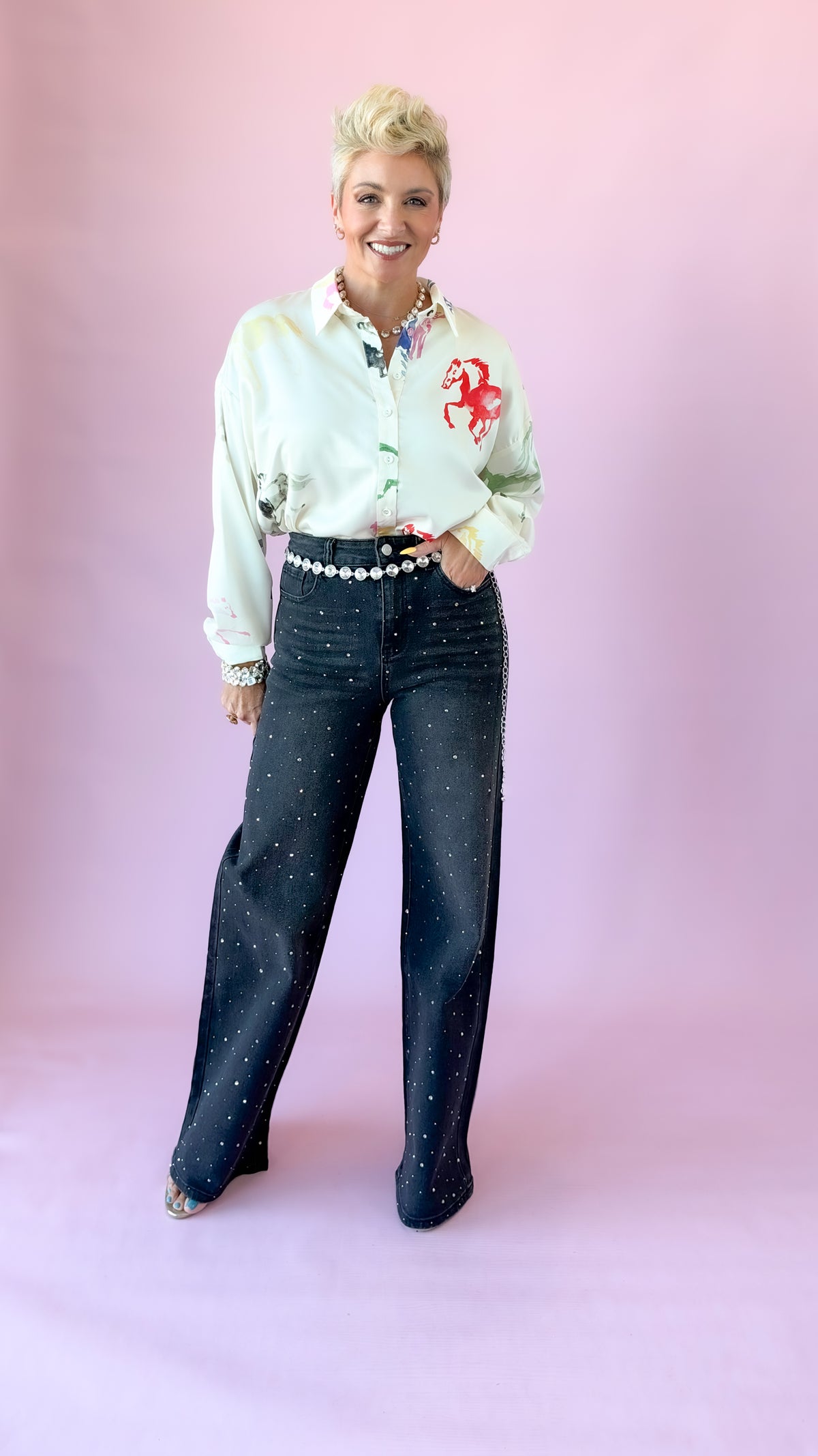 Full-length view of cream watercolor horse blouse with dark wide-leg jeans
