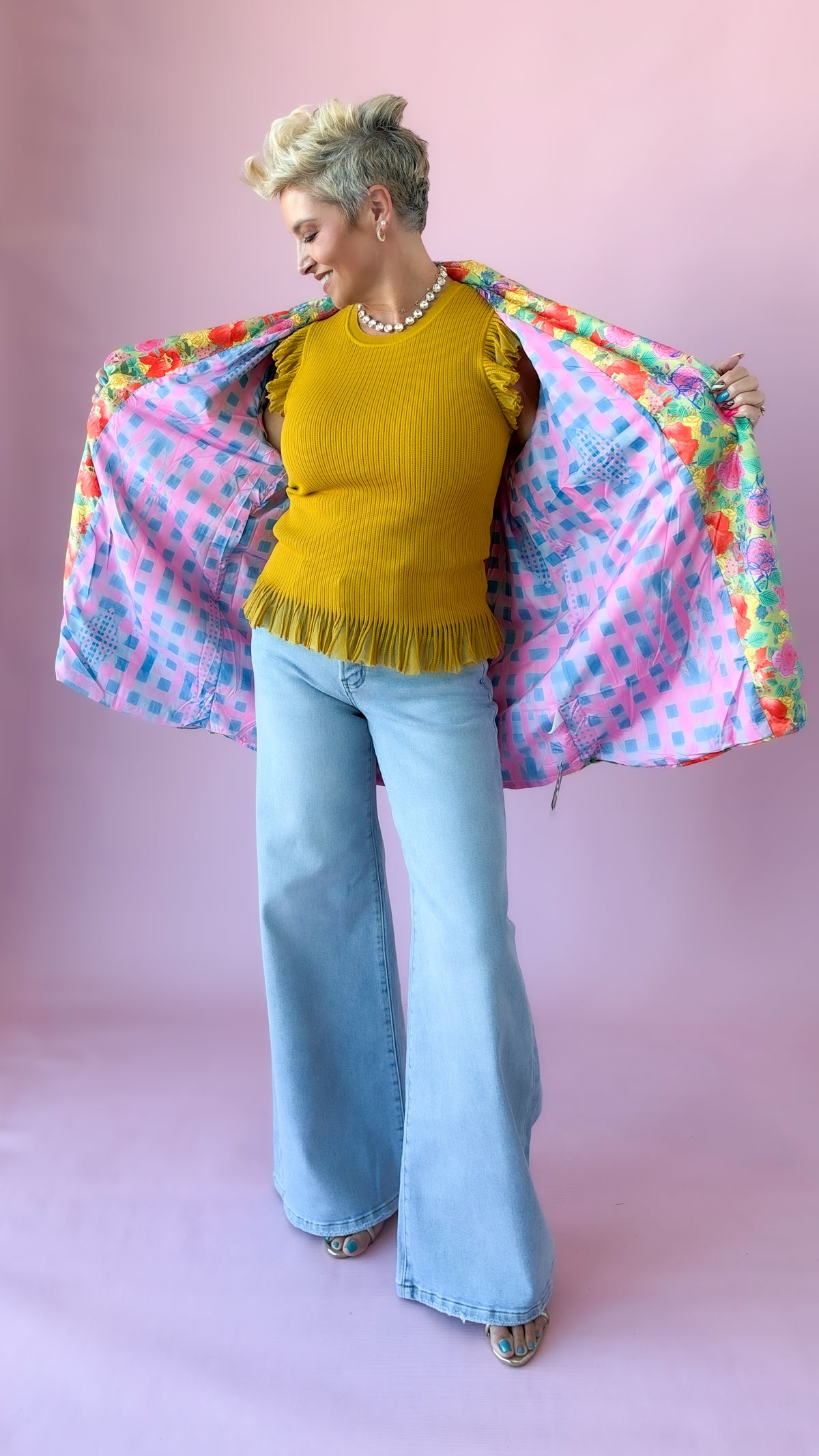 Full-length view of mustard Chelsea flutter sleeve sweater with wide-leg jeans and floral jacket