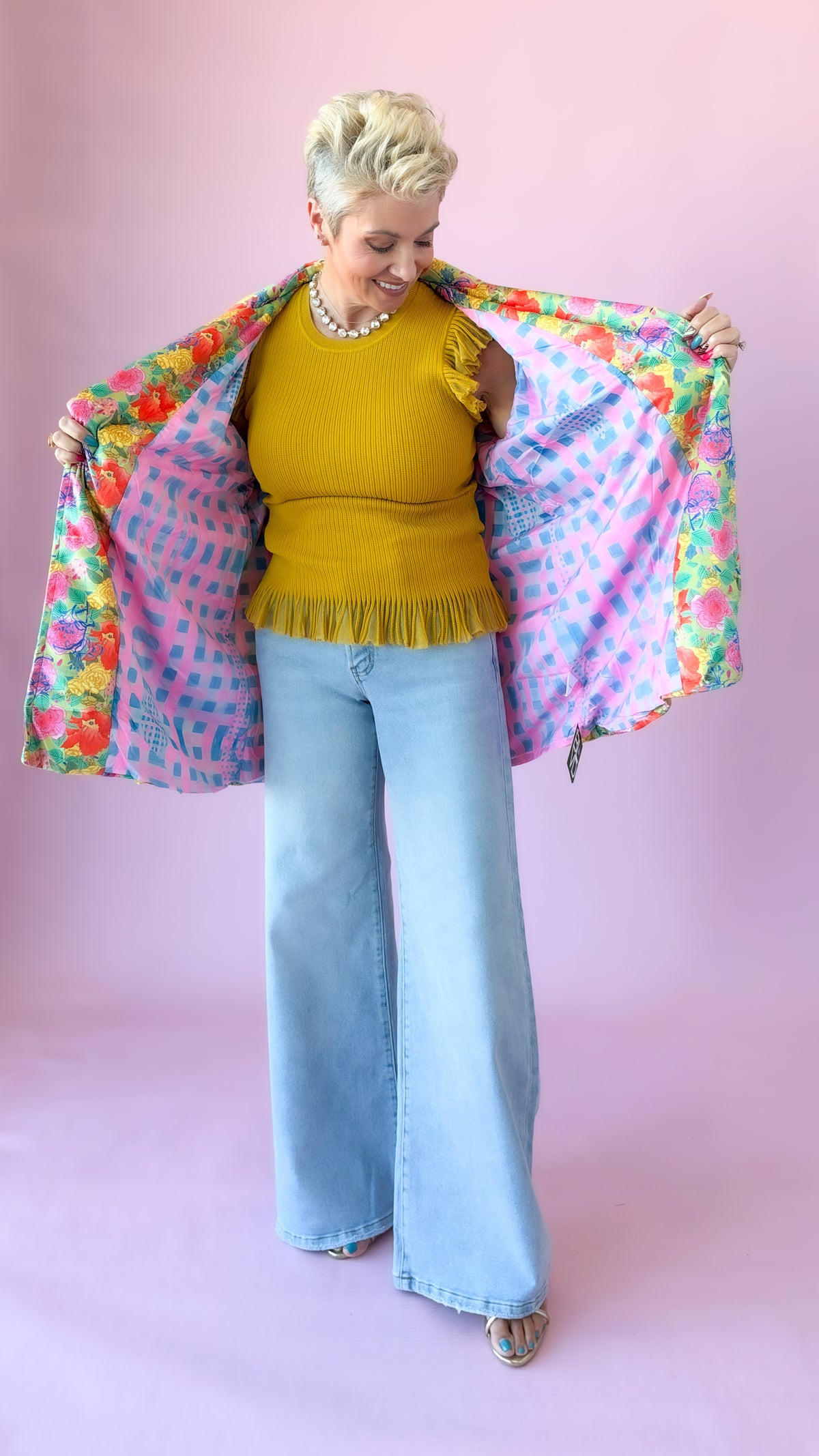 Mustard Chelsea flutter sleeve sweater with floral jacket held open, styled with wide-leg jeans