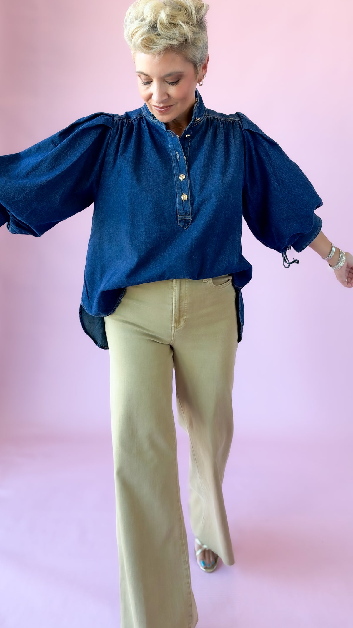 Dark denim Ingrid top with voluminous puff sleeves, shown mid-stride