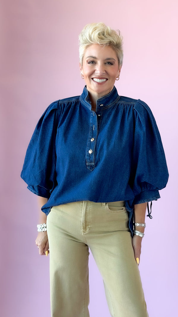 Dark denim Ingrid puff sleeve top with stand collar, styled with khaki pants