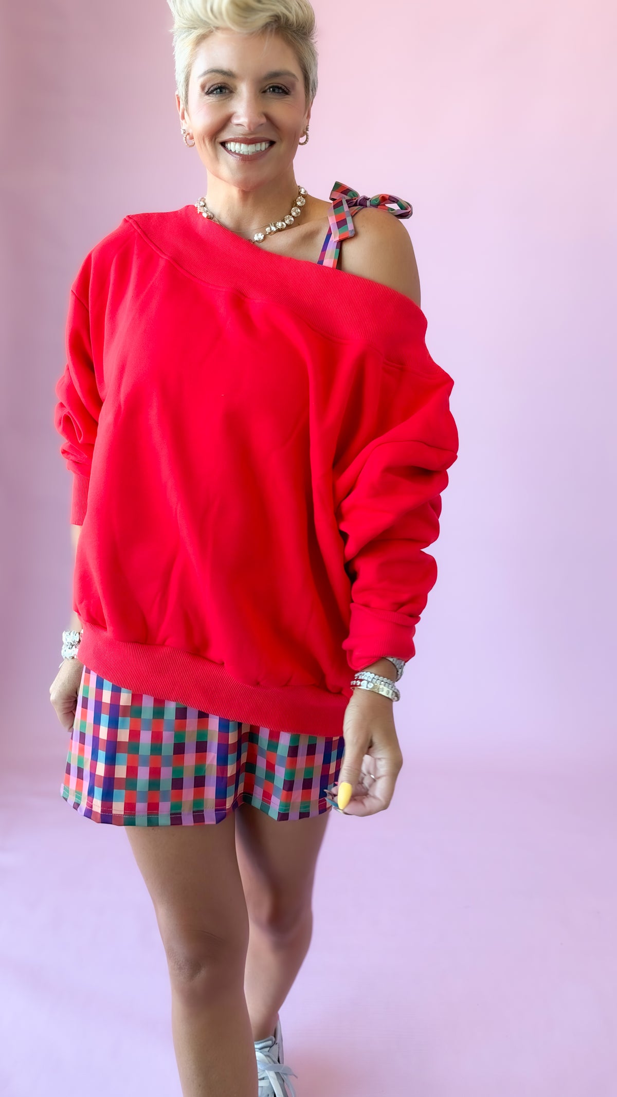 Red Harlow off-the-shoulder sweatshirt styled with plaid shorts