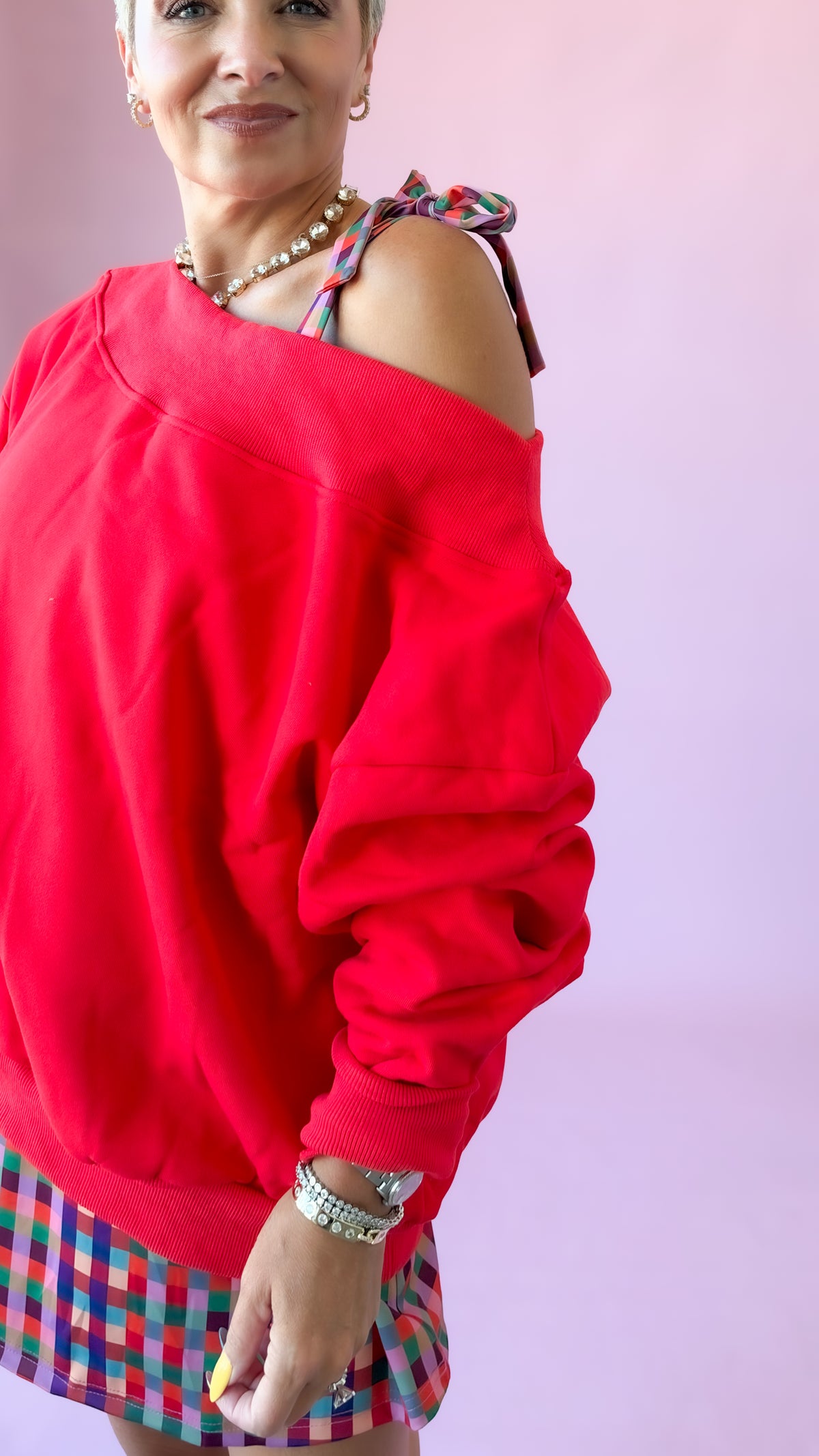 Close-up of red Harlow sweatshirt showing the off-the-shoulder neckline