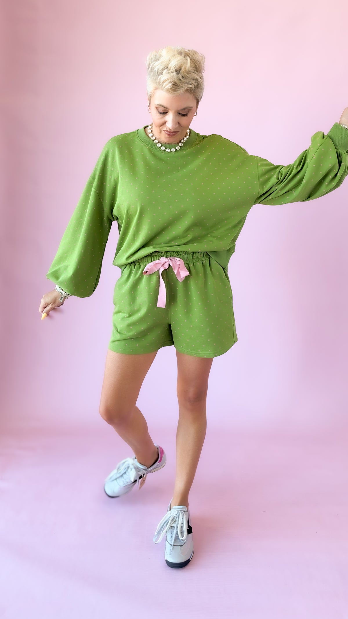 Green lounge pullover top with balloon sleeves, playful pose