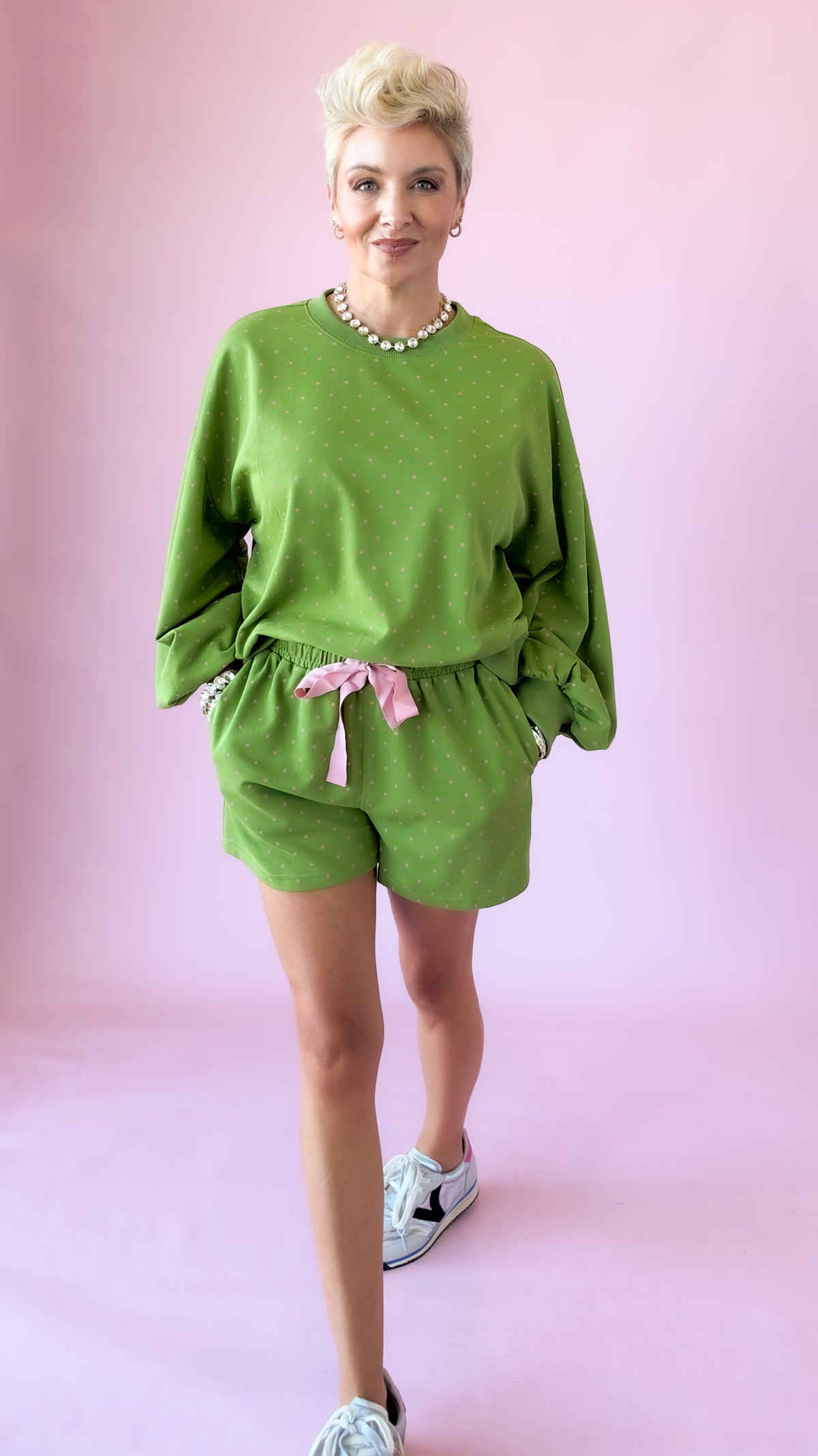 Green elastic waist lounge shorts with pink drawstring and matching sweatshirt