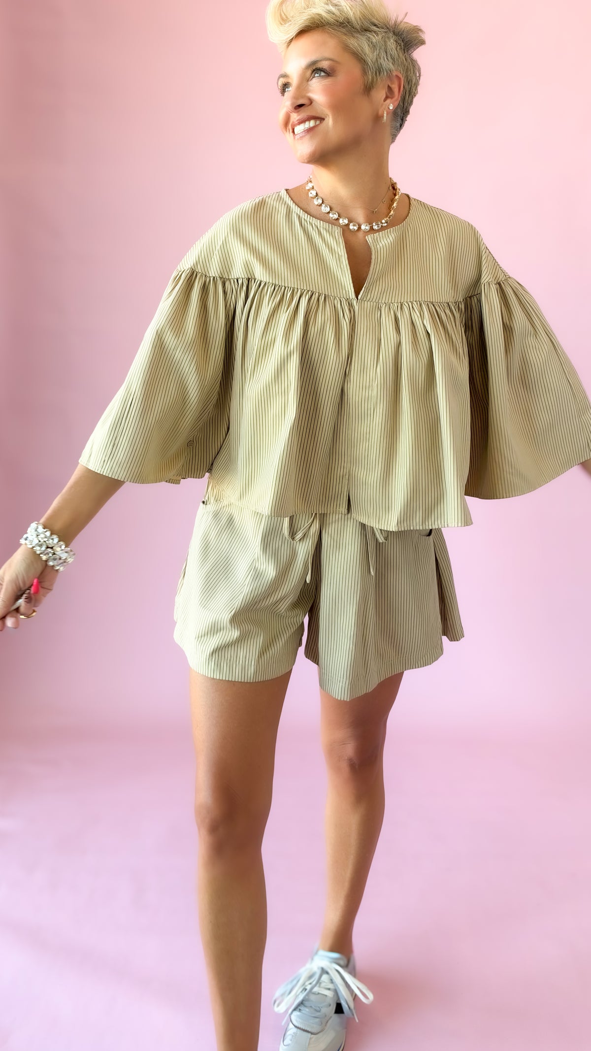Beige striped swing cape top shown in motion with matching shorts