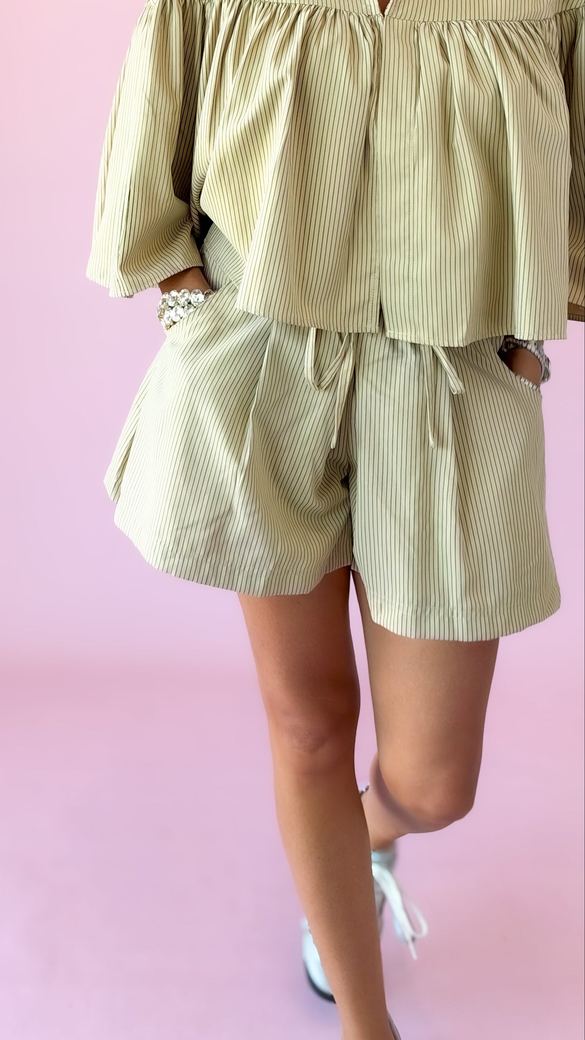 Close-up of beige striped elastic waist shorts with matching top