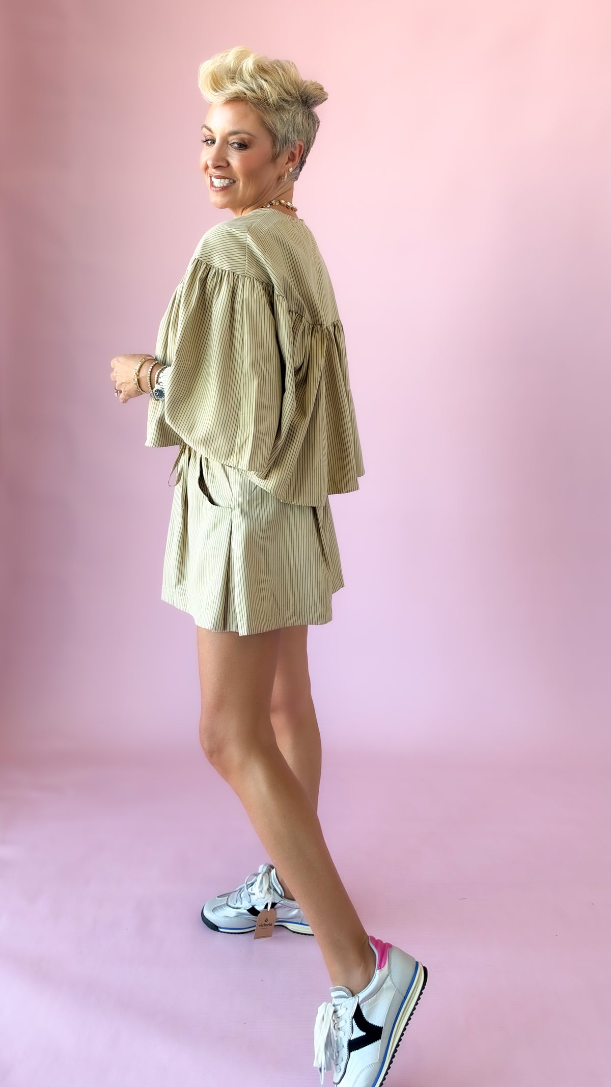 Side view of beige striped elastic waist shorts