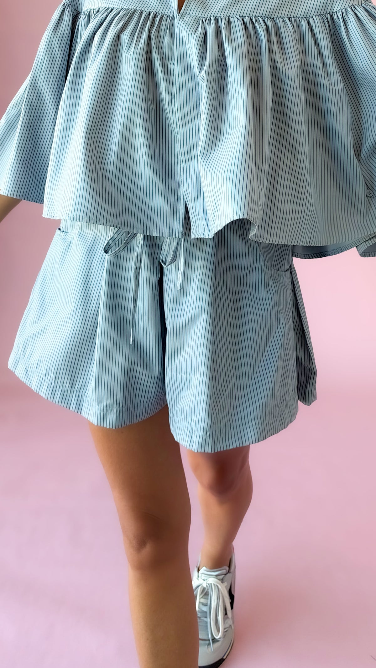 Close-up of light blue striped elastic waist shorts with matching top