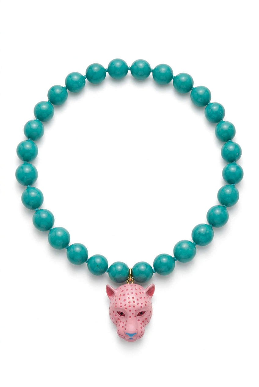 A beaded necklace featuring round turquoise-green beads and a pink leopard head pendant with gold accents, displayed on a clean white background.