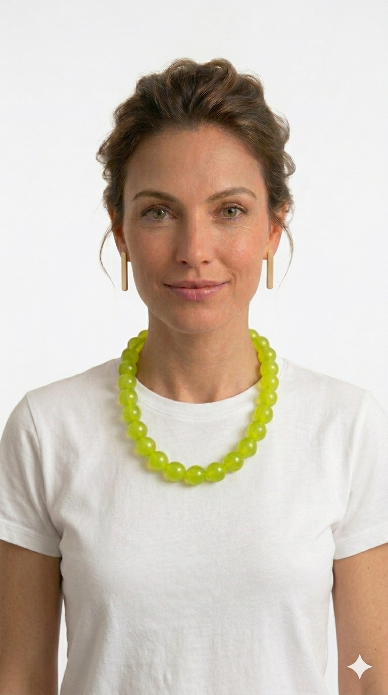 Woman wearing a bright green necklace against a white background