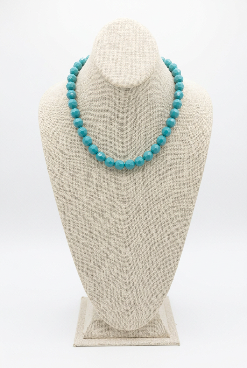 18-inch turquoise faceted bead necklace displayed on a beige linen jewelry bust