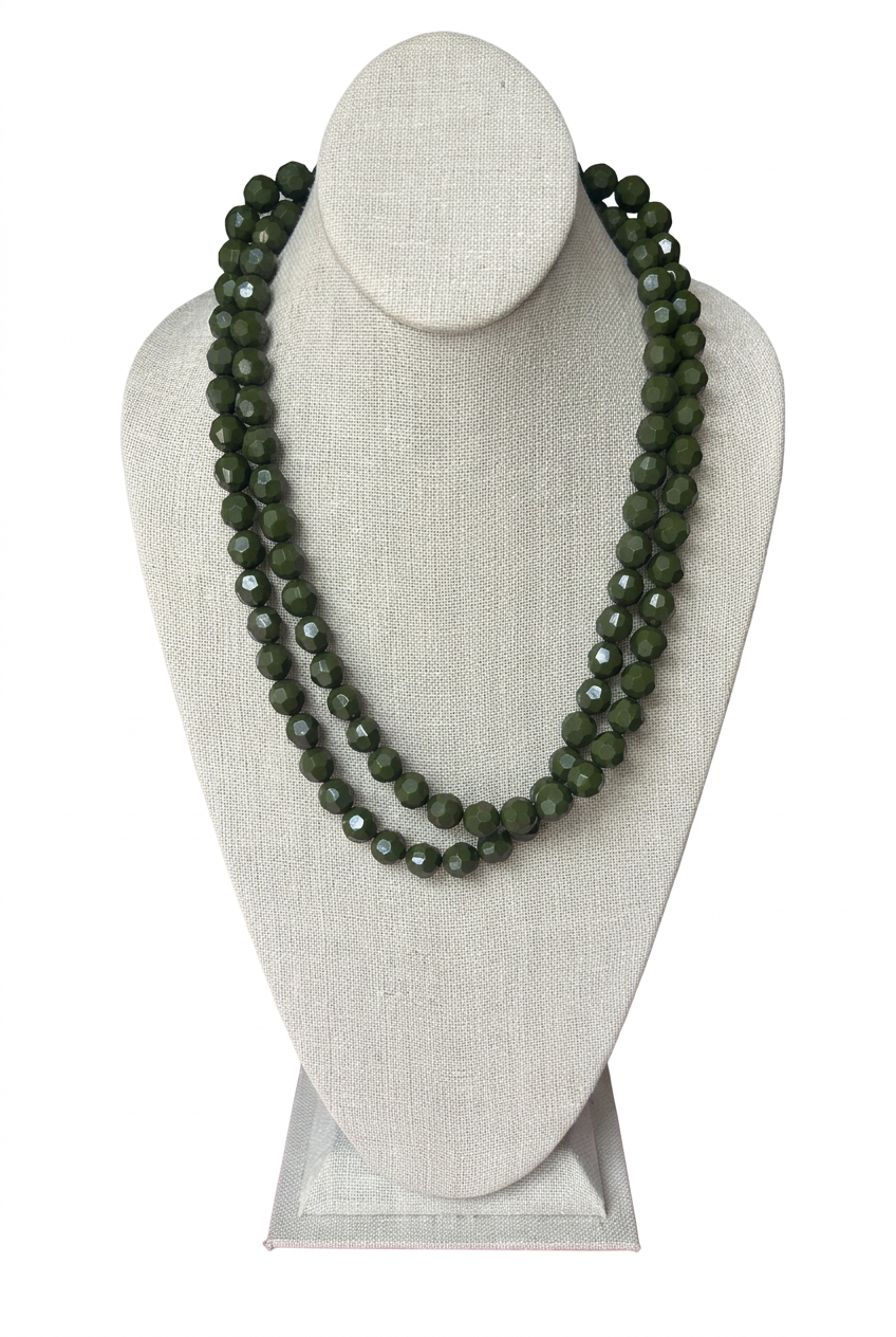 48-inch olive green faceted bead necklace worn doubled in two layered strands on a beige linen jewelry bust