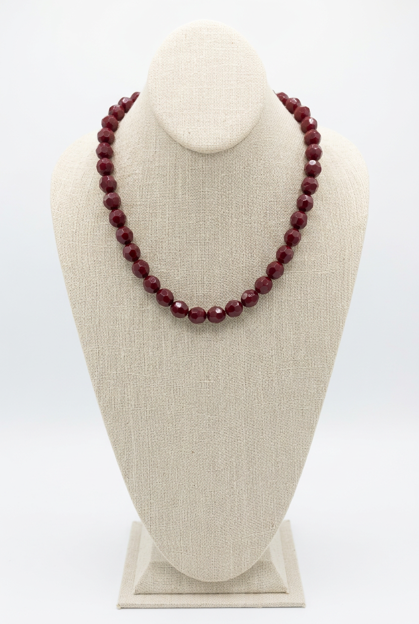 18-inch burgundy faceted bead necklace displayed on a beige linen jewelry bust