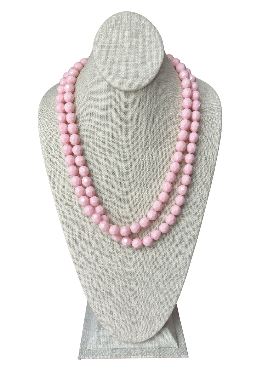 48-inch light pink faceted bead necklace worn doubled in two layered strands on a beige linen jewelry bust