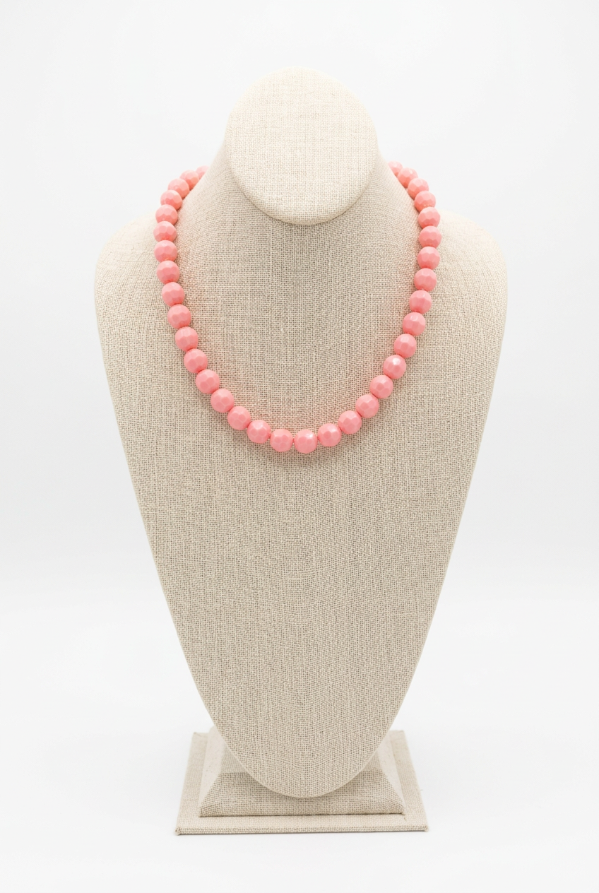 18-inch pink faceted bead necklace displayed on a beige linen jewelry bust