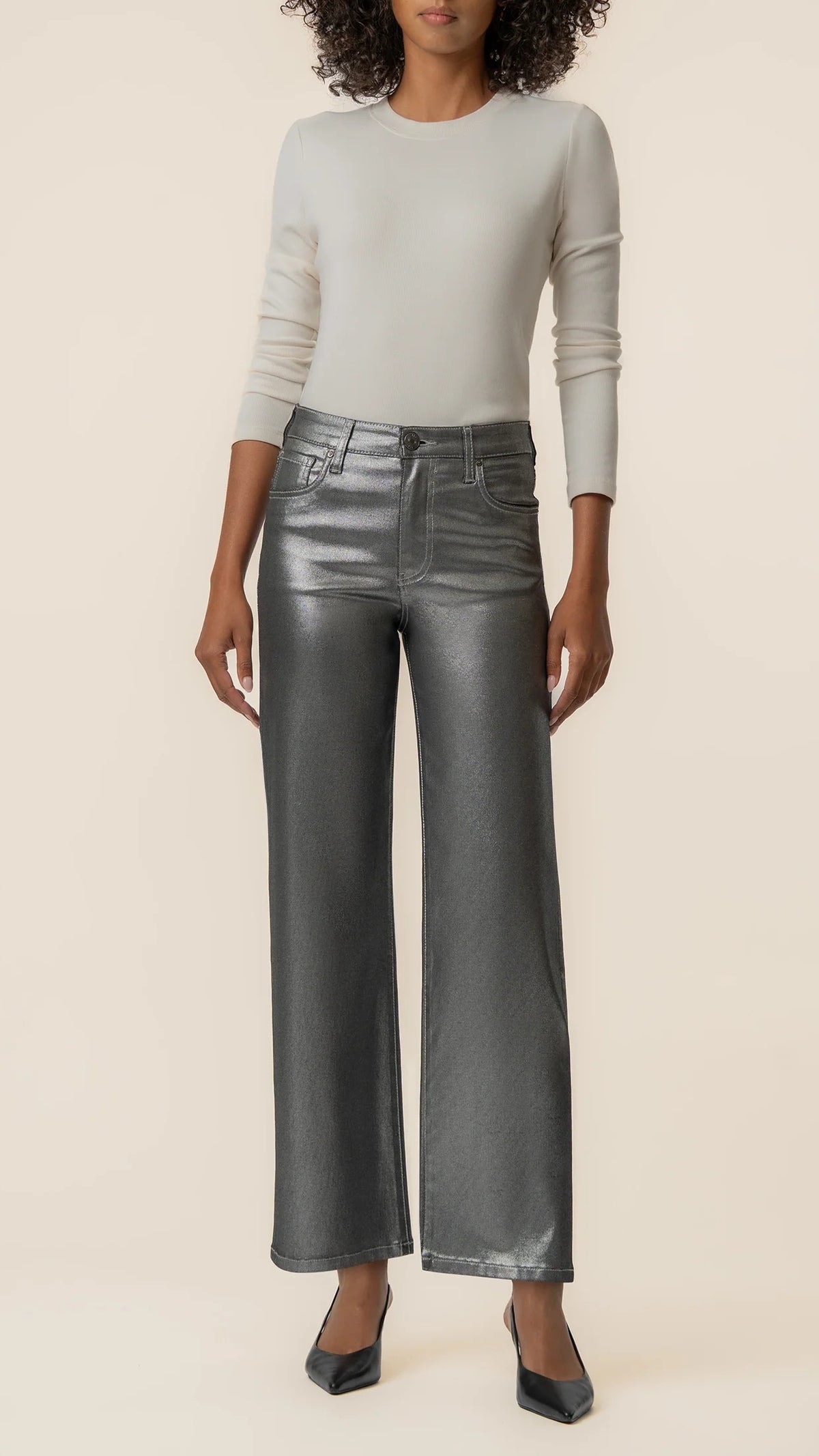 Front view of matte silver wide leg jeans styled with black pointed heels