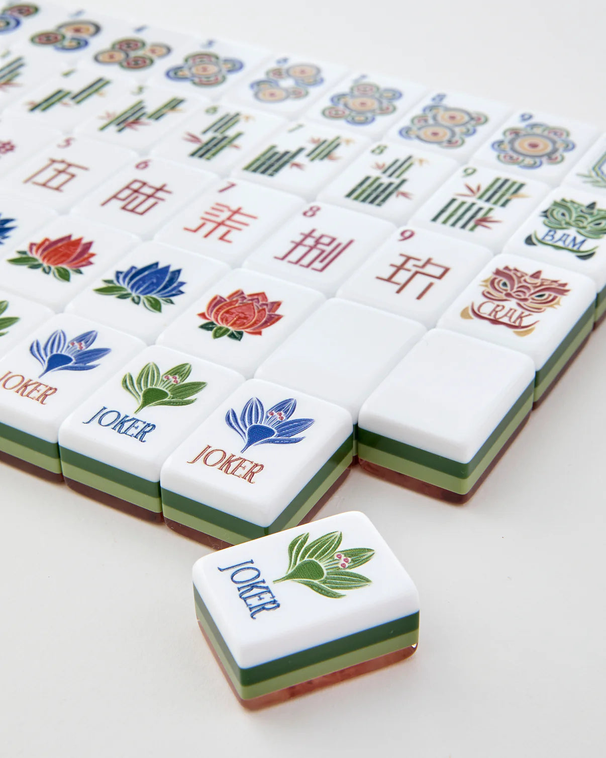 Mahjong tiles with colorful designs and 'Joker' tiles on a white background