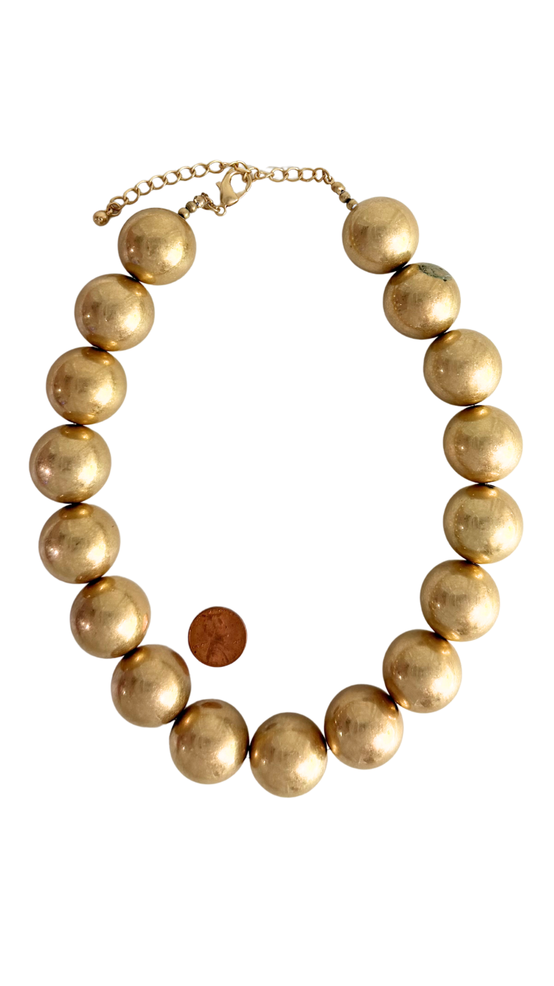 Gold beaded necklace on a white background