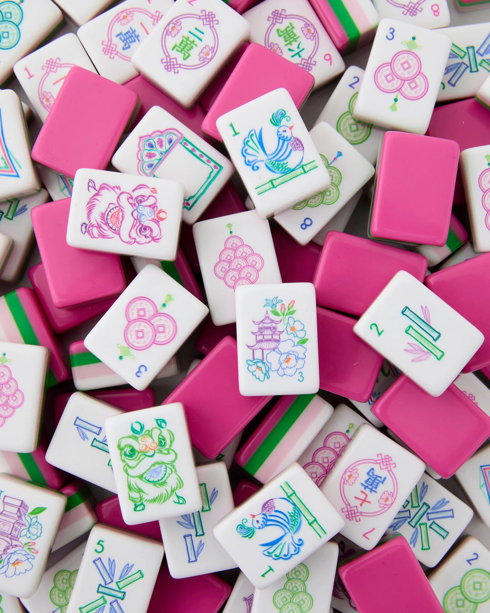Colorful Mahjong tiles with various designs on a pink background