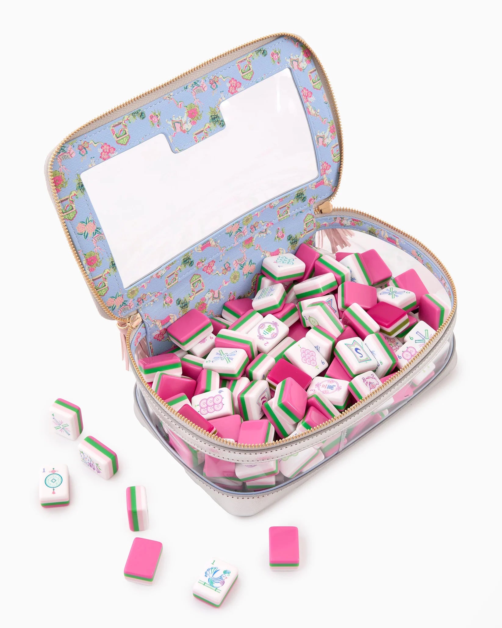 Small suitcase with pink and white items inside on a white background
