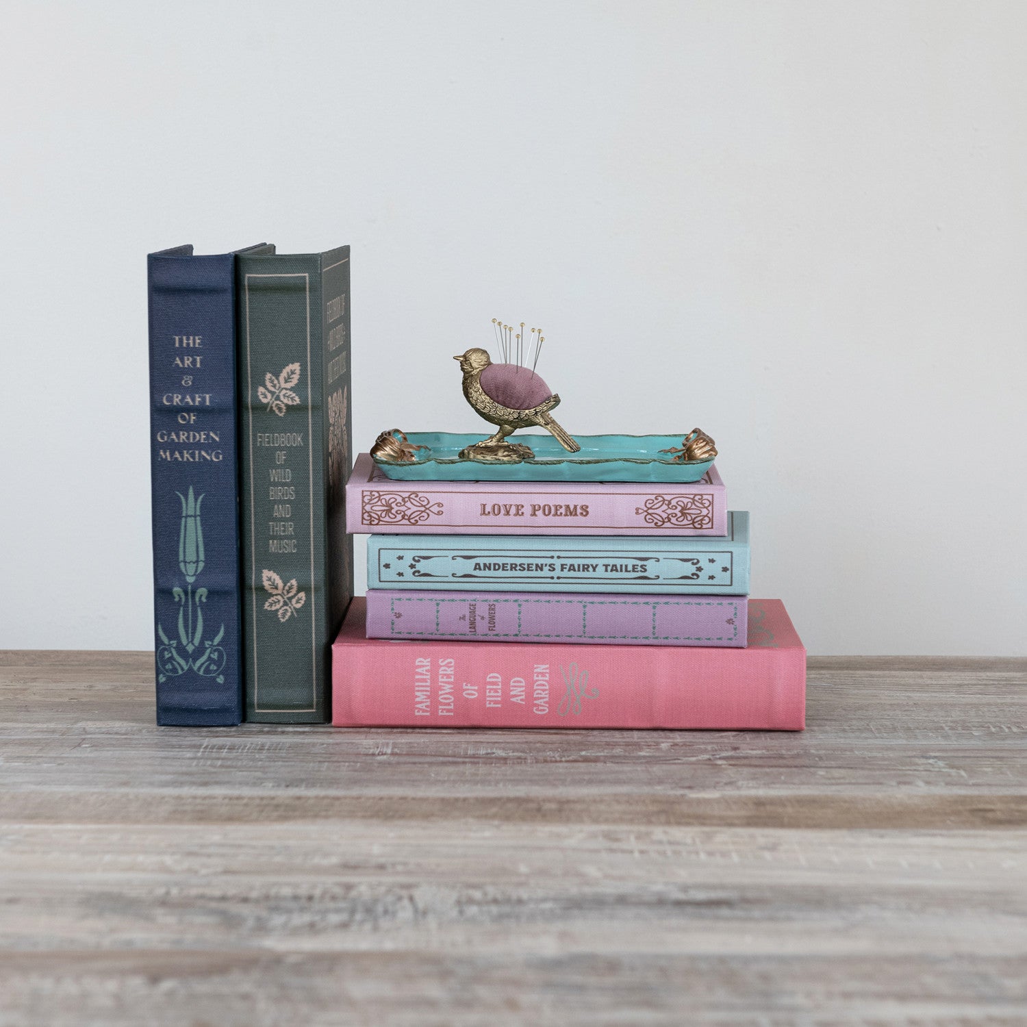 Stack of books with decorative items on a wooden surface