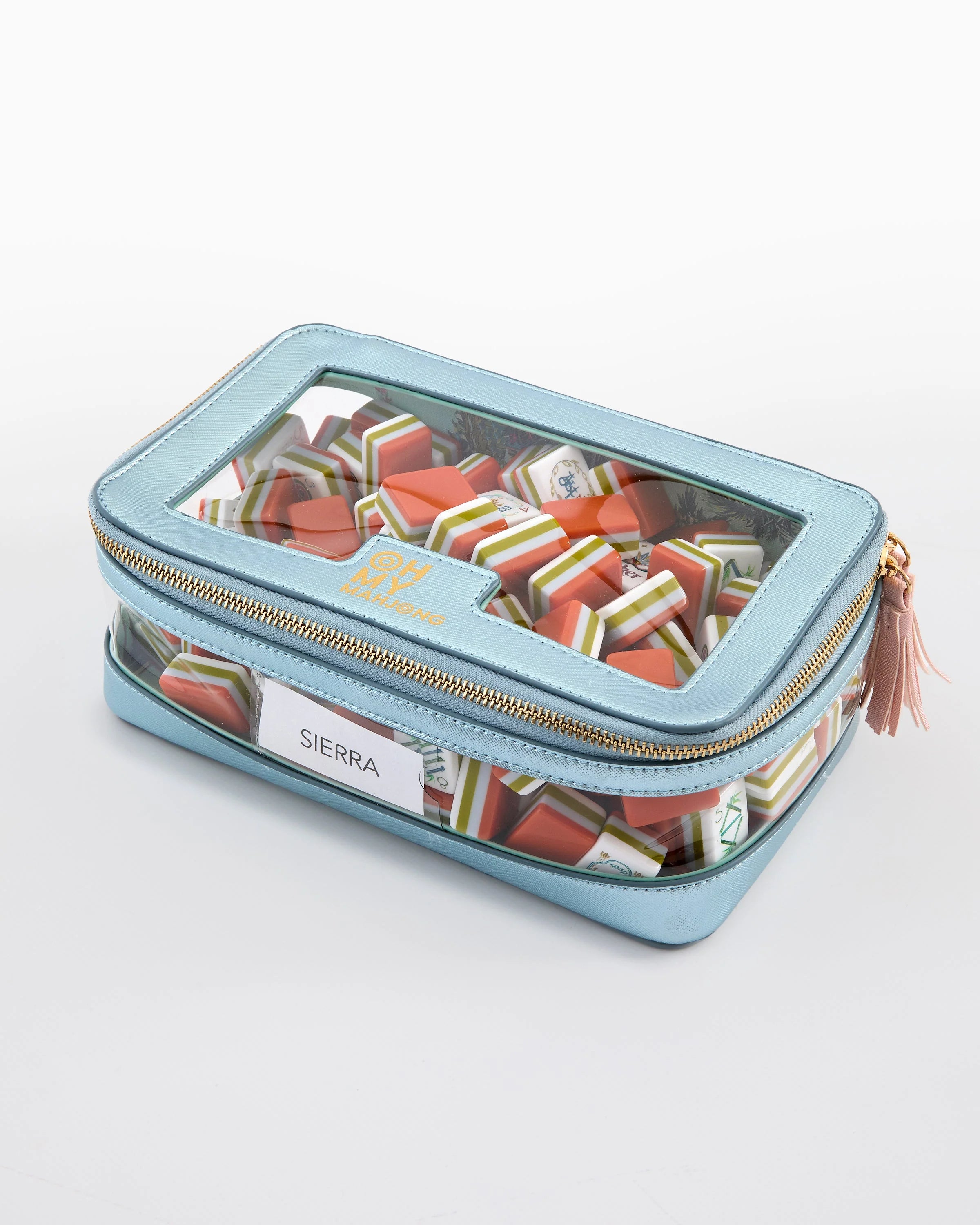 Blue rectangular travel case with a clear lid containing colorful items on a white background