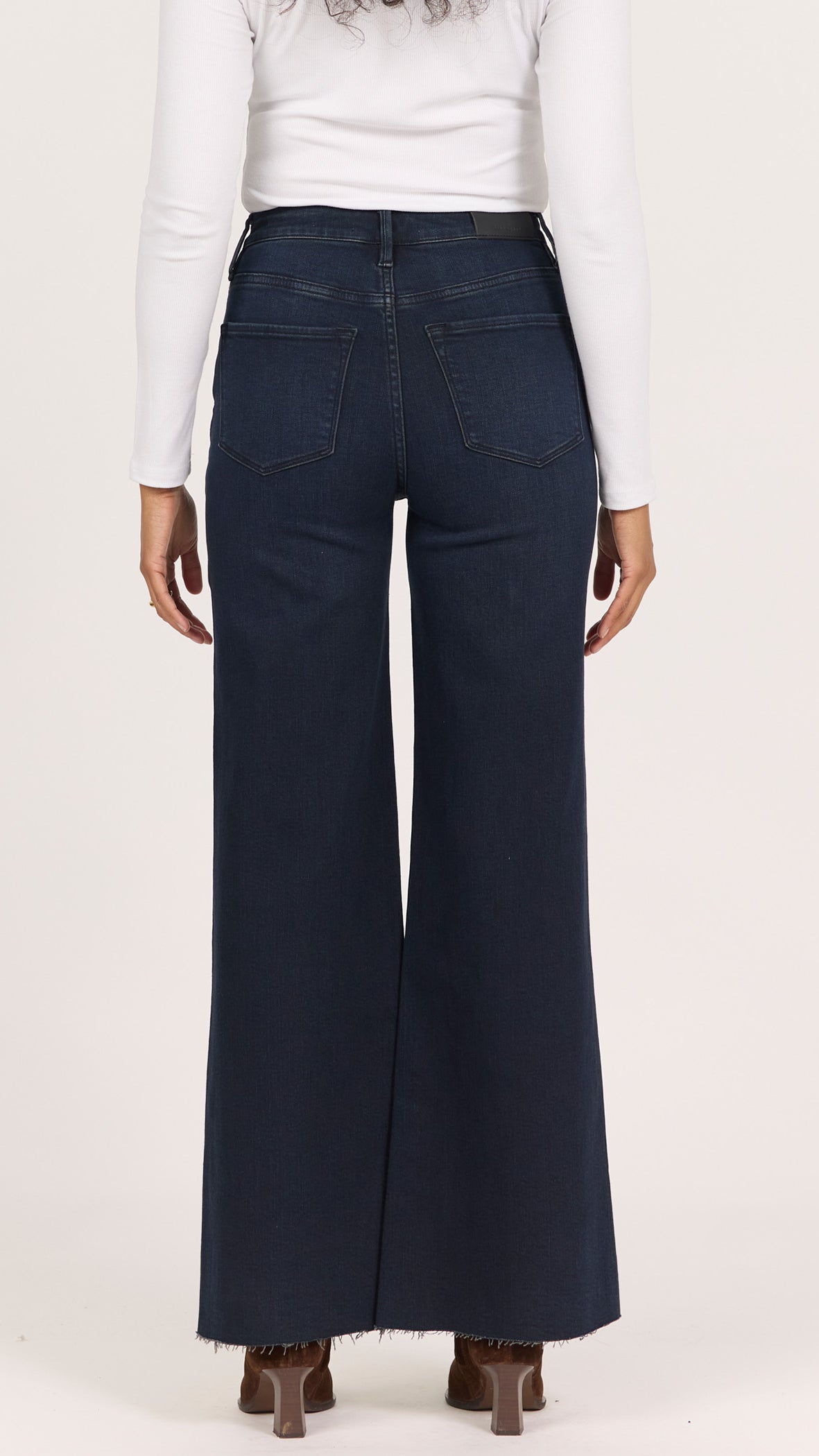 Back view of inkwell Fiona wide leg jeans showing the back pockets and raw cut hem