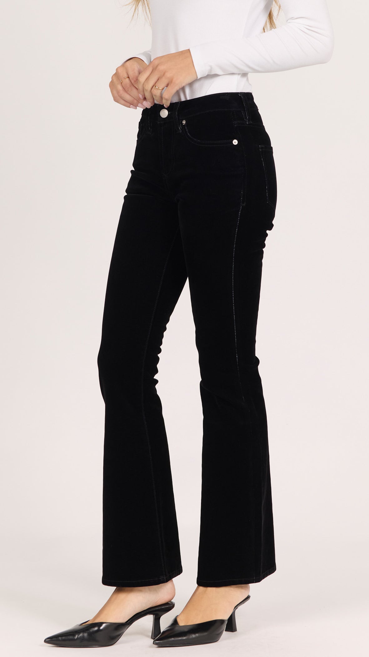 Three-quarter side view of black velvet Jaxtyn bootcut pants with black pointed heels