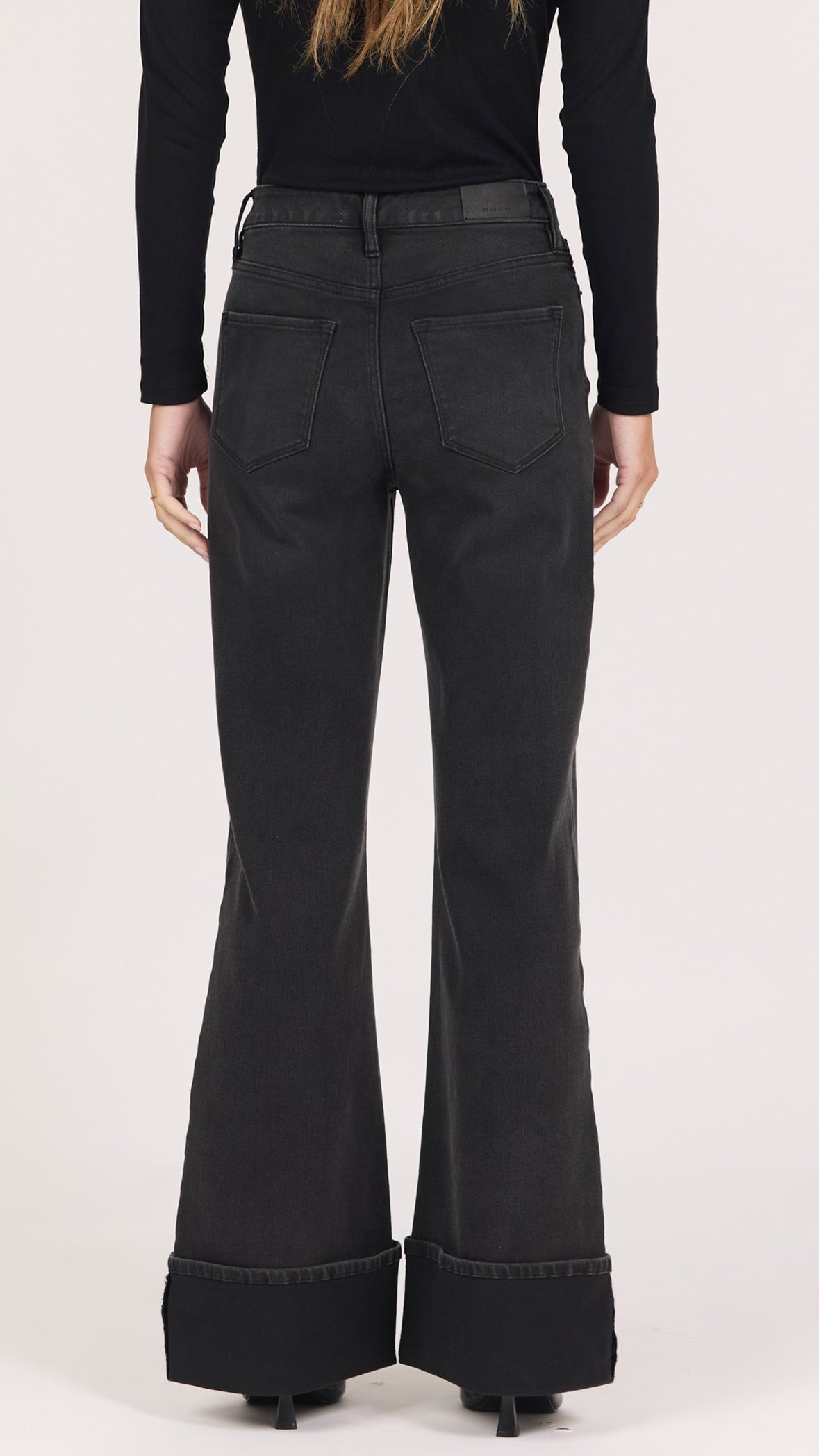 Back view of midnight washed black Fiona jeans showing the back pockets and cuffed hem