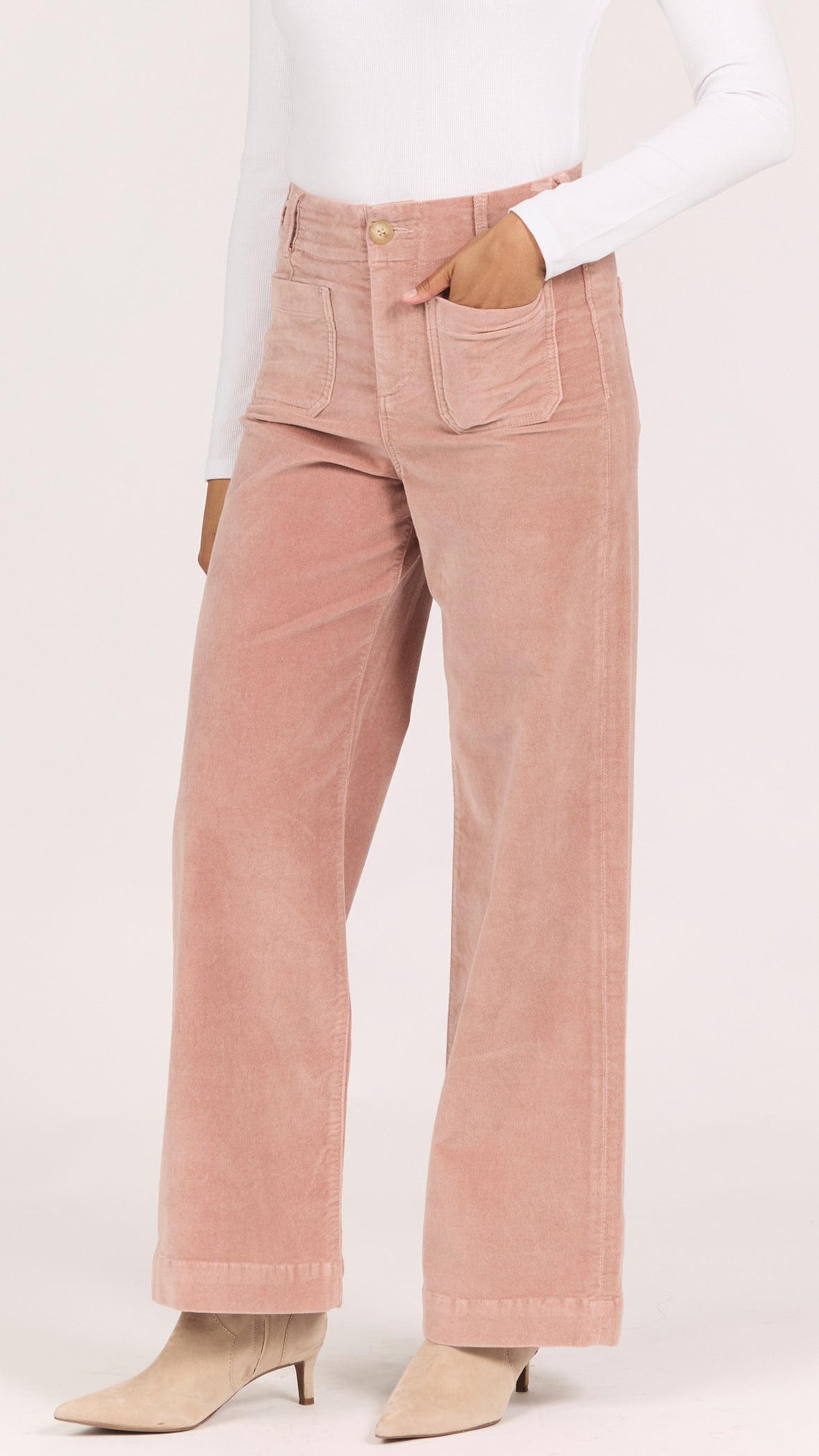 Three-quarter side view of dusty rose corduroy Audrey wide leg pants with cream heeled ankle boots
