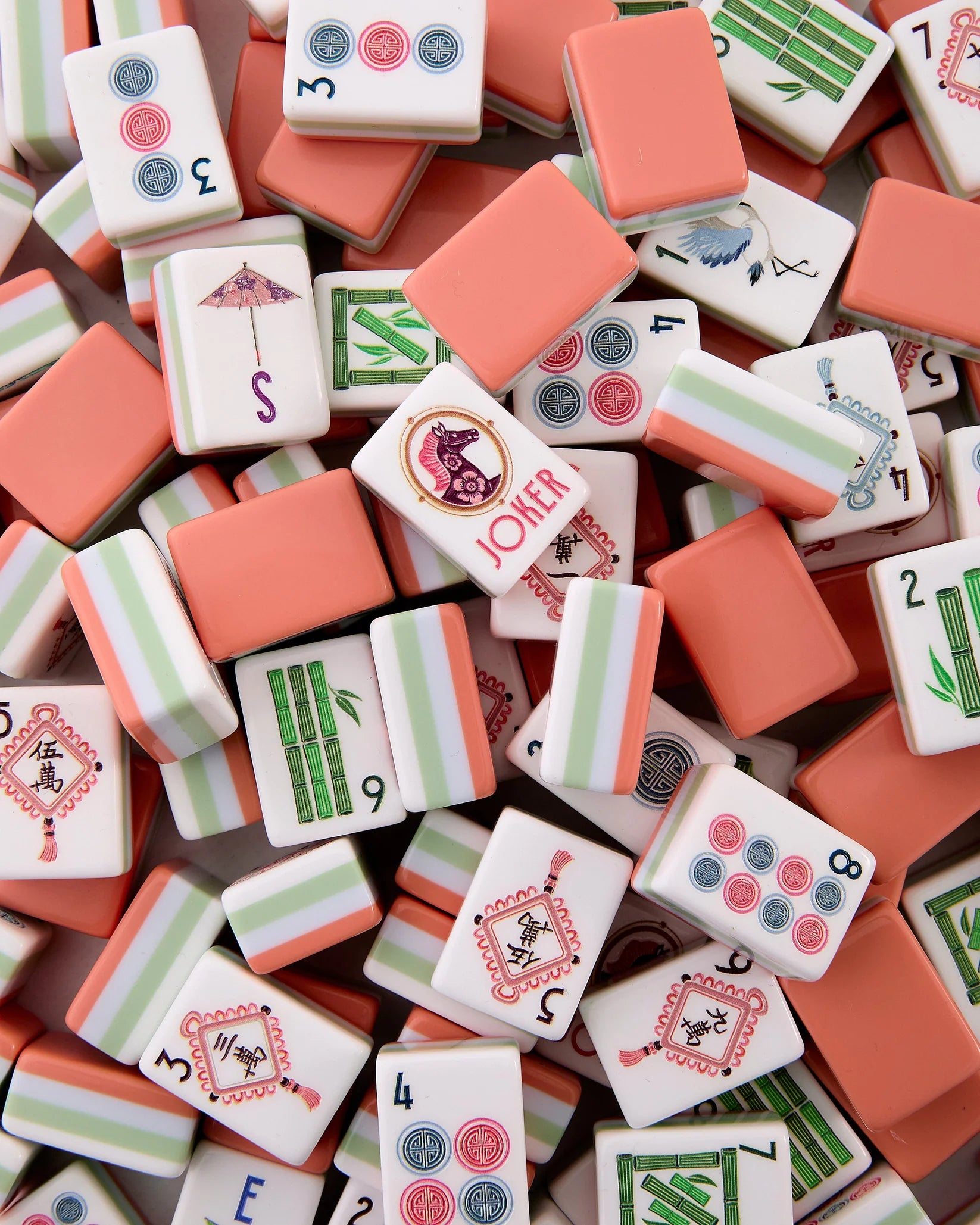 Close-up of assorted mahjong tiles with various designs and numbers.
